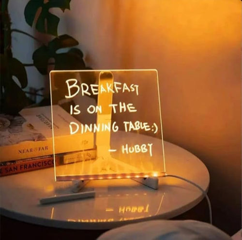 Glowing LED acrylic message board on a bedside table with a handwritten note