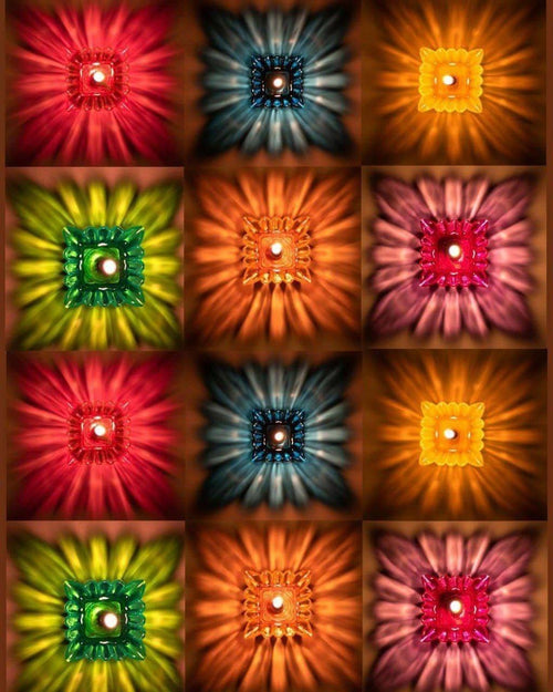 Grid of lit lotus reflection diyas in red, blue, orange, green and pink casting star-burst light patterns