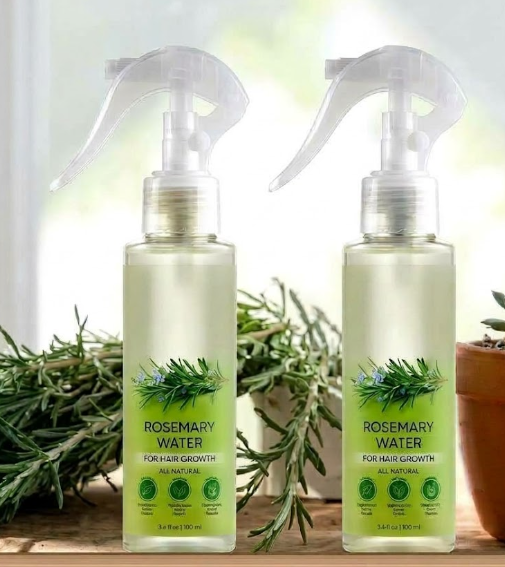 Two 100 ml Rosemary Water hair spray bottles beside fresh rosemary